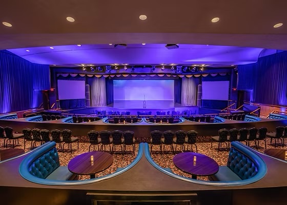 The stage, banquettes and audience seating inside the Celebrity Theatre at The Claridge Hotel